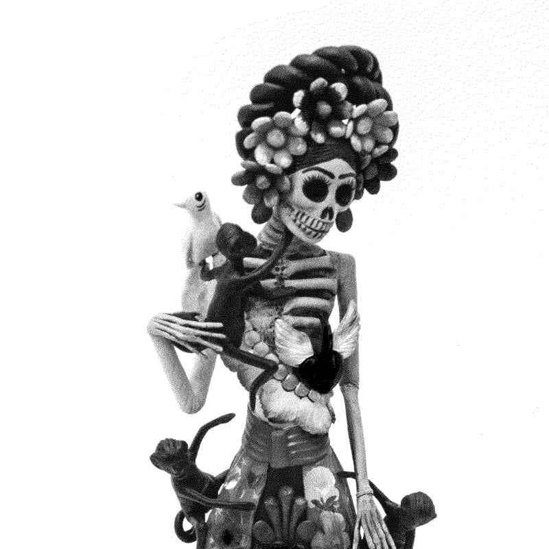Figura de catrina de barro con un perico sobre el hombro